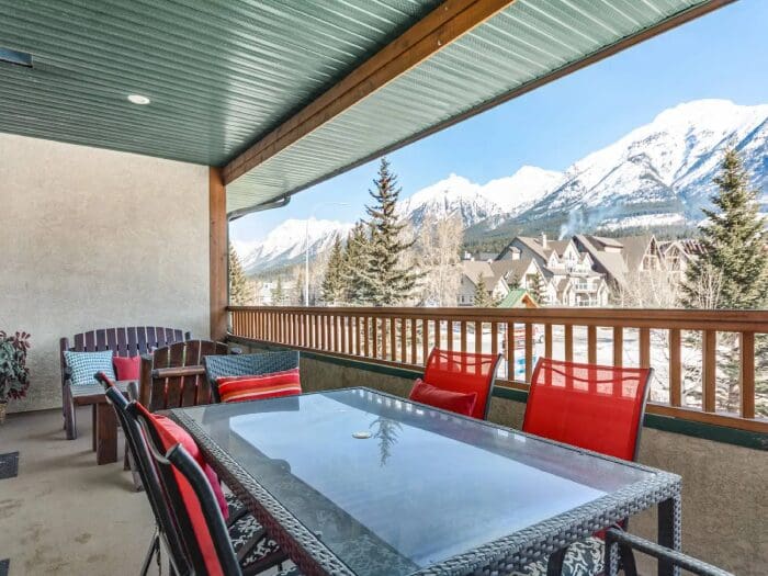 Balcony patio with mountain view and table.