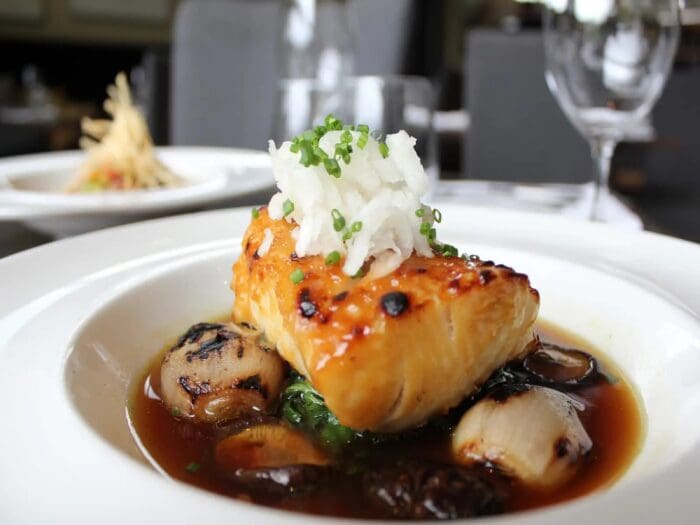 Glazed fish with mushrooms and broth.