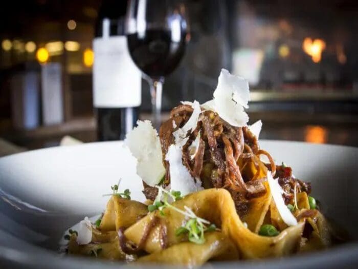 Pasta dish with meat, cheese, and wine.