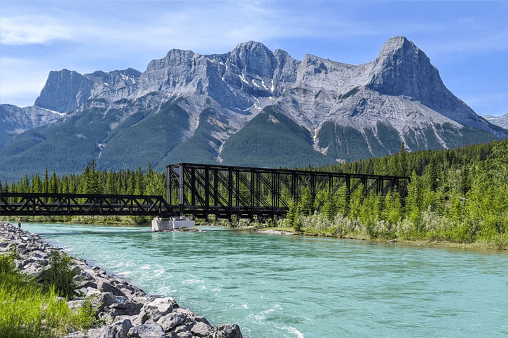 Bridge over a river with mountains in the background.